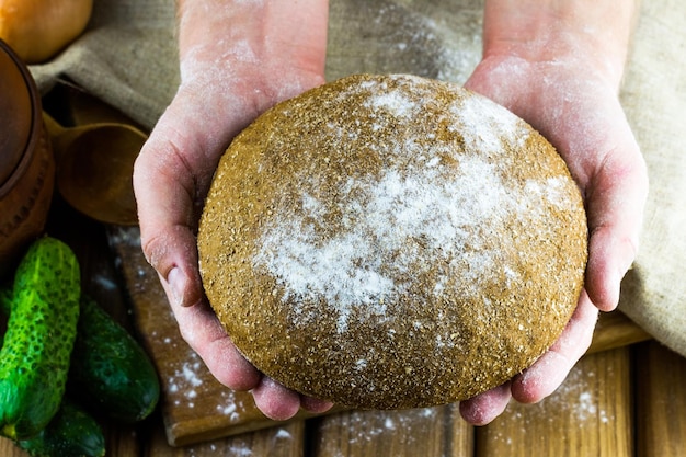 Vers gebakken brood in de handen van een bakker