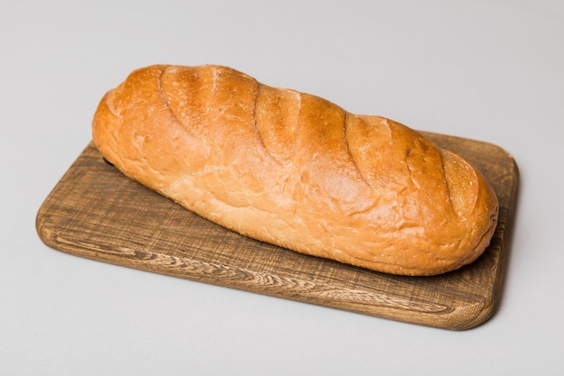 Vers gebakken brood op snijplank tegen witte houten achtergrond perspectief weergave brood met kopie ruimte