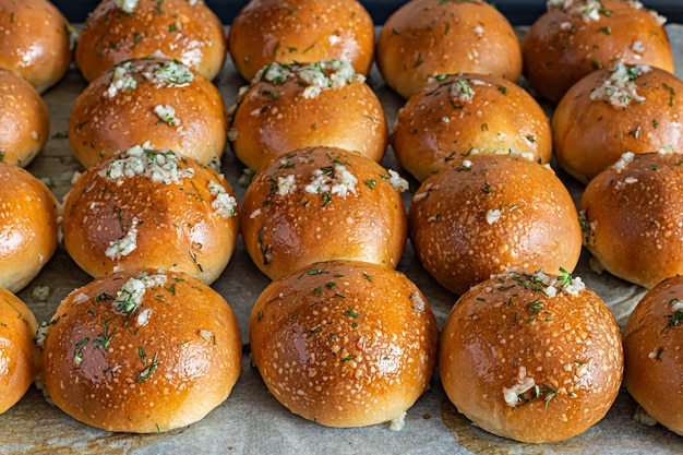 Vers gebakken broodjes (pampushki) met knoflook en dille voor het voorgerecht (soep) op een bakplaat.