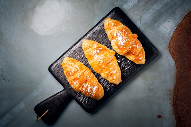 Vers gebakken croissant bestrooid met poedersuiker op tafel