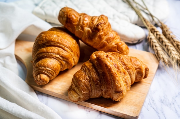 Vers gebakken croissants op houten snijplank.