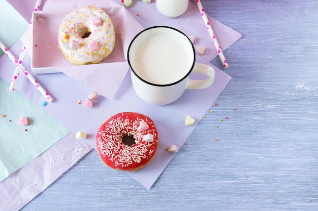 Vers gebakken donuts geglazuurd en besprenkeld met karamelhartenmelk en yoghurt in een kopje