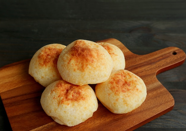 Vers gebakken huisgemaakt Braziliaans kaasbrood of Pao de Queijo op een houten broodplank