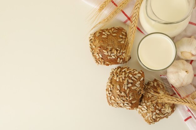 Vers gebakken knoflookbroodjes en melk op witte lijst