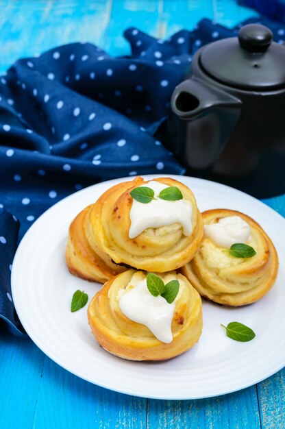 Vers gebakken kwarkbroodjes met room en muntblaadjes