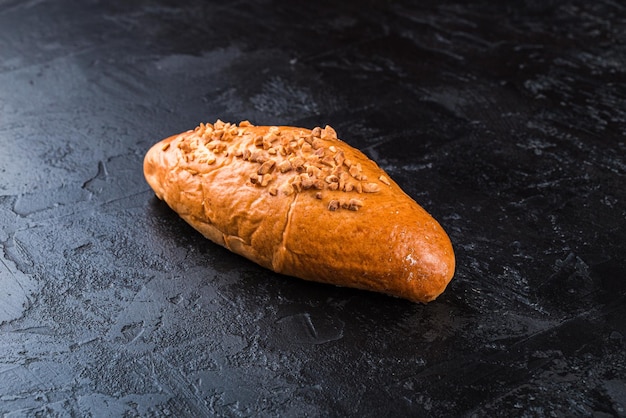 Vers gebakken lekker broodje op een donkere tafel lekker gebakken goederen rechtstreeks van de bakkerij zwarte pagina