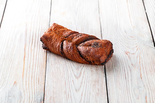 Vers gebakken lekker broodje op een witte houten tafel Lekker gebakken goederen rechtstreeks van de bakker