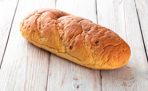 Vers gebakken lekker broodje op een witte houten tafel Lekker gebakken goederen rechtstreeks van de bakker