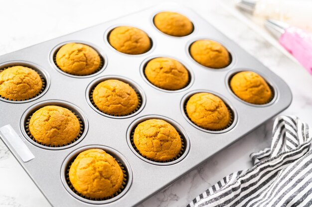 Vers gebakken pompoenkruid cupcake koeling in cupcake pan.