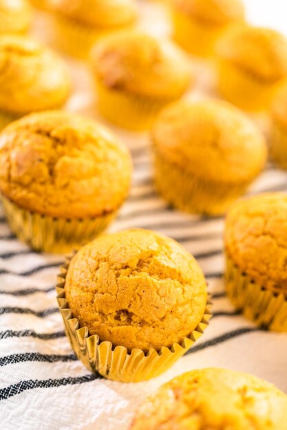 Vers gebakken pompoenkruid cupcake koeling op keukenhanddoek.