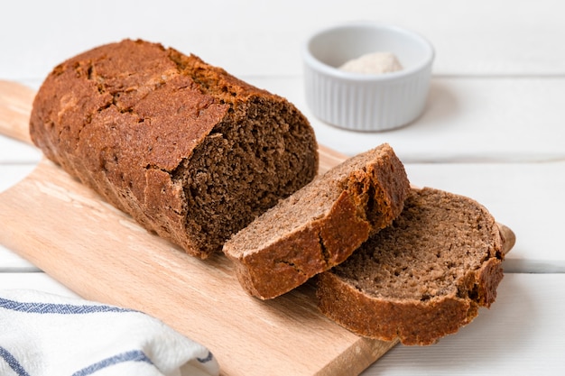 Vers gebakken roggebrood gesneden op een houten bord lichte houten achtergrond met kopieerruimte