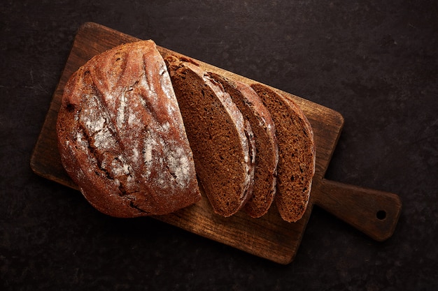 Vers gebakken ronde gesneden brood op donkergrijze keukentafel