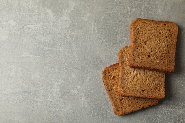 Vers gebakken sneetjes roggebrood op grijze achtergrond