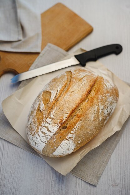 Vers gebakken tartin brood en een mes op een houten bord