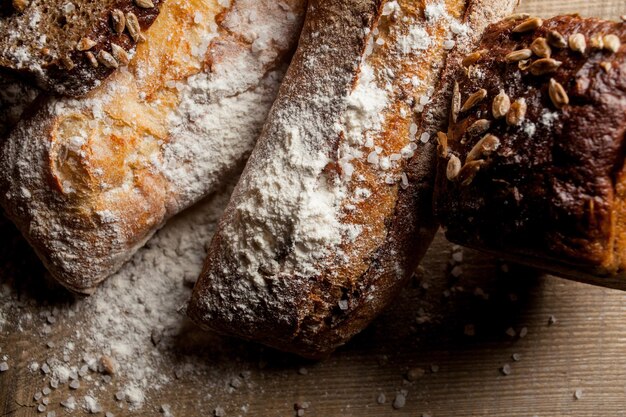 Vers gebakken traditioneel brood met bloem op houten tafel vers stokbrood met bloem