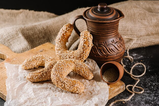 Vers gebakken zoete broodjes met pot en stof op de zwarte houten achtergrond