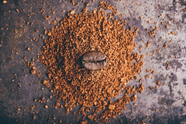 Vers gebrande koffieboon ligt op een hoop gemalen koffie