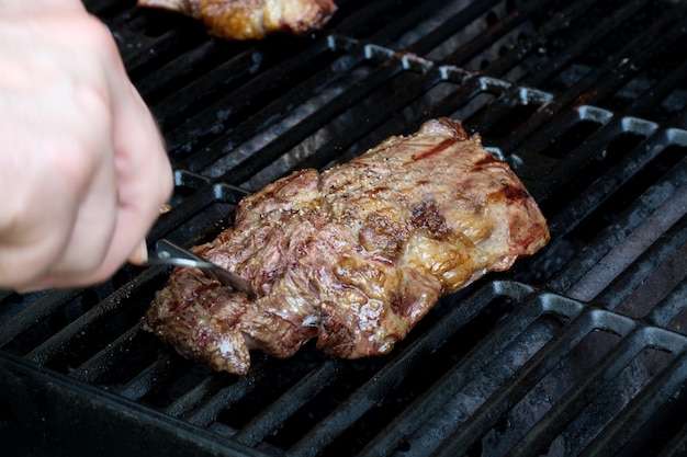 Vers gegrild vlees. Grillen van steaks op vlammende grill. Hoge kwaliteit foto