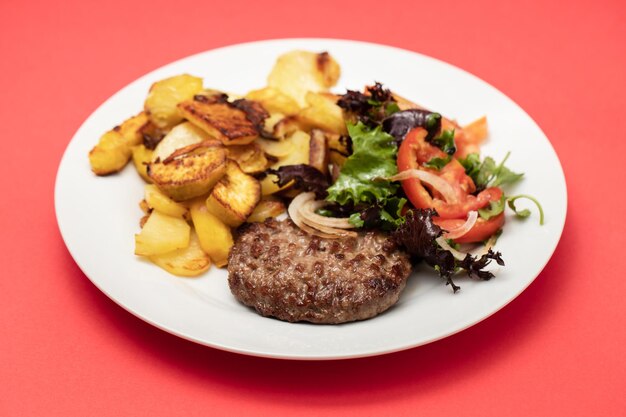 Vers gegrilde hamburgers met aardappel en salade in kleine kom