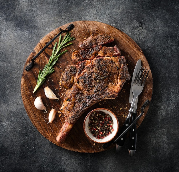 Vers gegrilde Tomahawk steak op een houten snijplank BBQ-voedsel bovenaanzicht grijze achtergrond