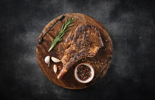 Vers gegrilde tomahawk steak op een houten snijplank bbq-voedsel bovenaanzicht grijze achtergrond