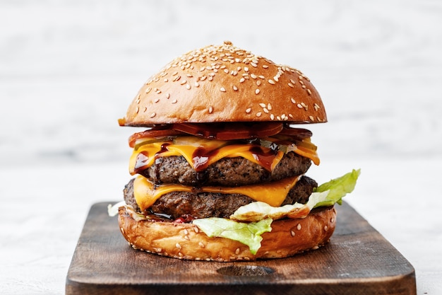 Vers gekookte hamburger op een houten bord op lichte achtergrond