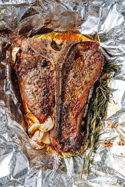 Vers gekookte sappige tbone steak met rozemarijn en knoflookkruiden op een lichte marmeren achtergrond