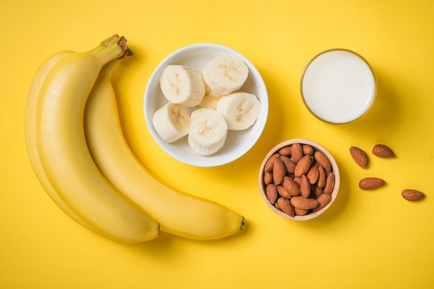 Vers gemaakte bananensmoothie in een glas op gele achtergrond