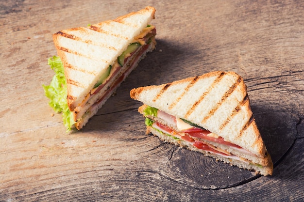 Vers gemaakte clubsandwiches geserveerd op een houten snijplank