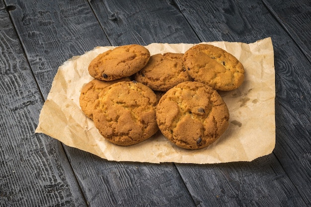 Vers gemaakte havermoutkoekjes op papier op een zwarte houten tafel