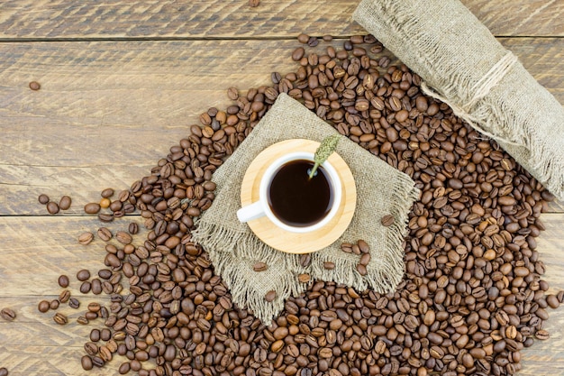 Vers gemaakte koffie in een kopje op een houten landelijke tafel en koffiebonen. bovenaanzicht. rustieke stijl.