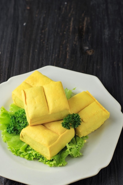 Vers gemaakte rauwe tahoe gele Bandung Tofu op zwarte houten tafel