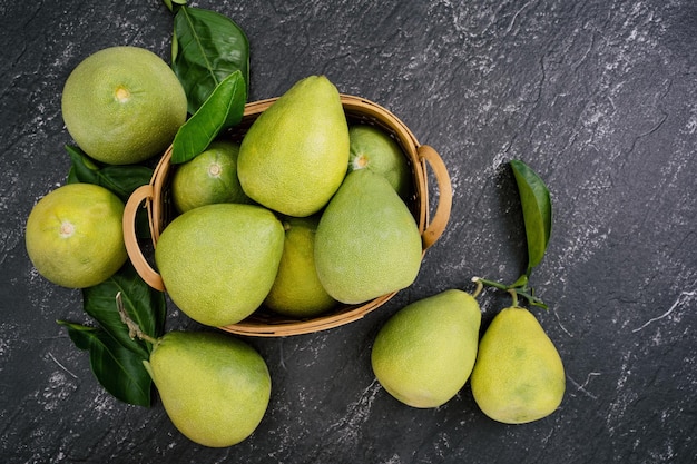 Vers gepelde pomelo pummelo grapefruit shaddock op donkere achtergrond in bamboe mand Herfst seizoensfruit bovenaanzicht plat lag tafelblad schot