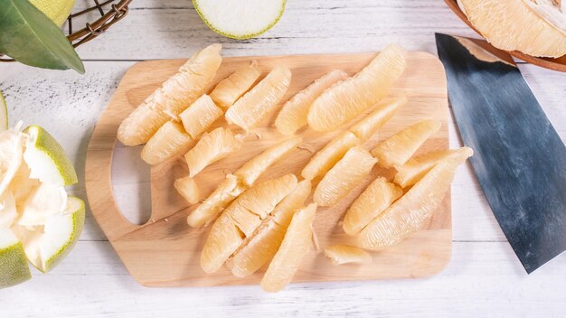 Vers gepelde pomelo pummelo grapefruit shaddock op heldere houten achtergrond Herfst seizoensfruit bovenaanzicht plat lag tafelblad shot