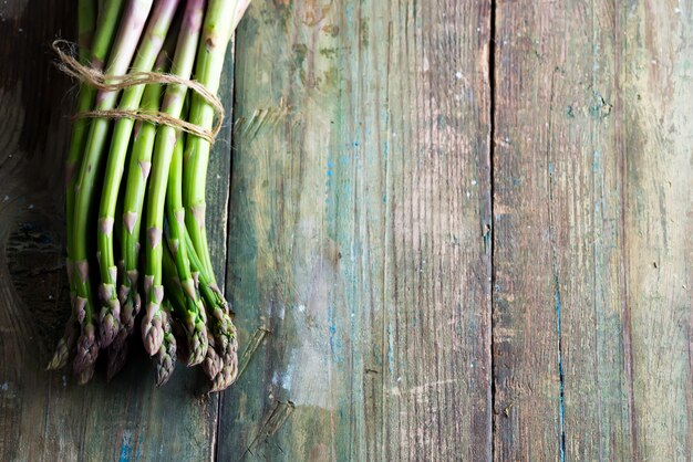 Vers geplukte natuurlijke organische aspergebos op houten achtergrond.