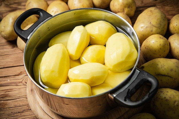 Vers geschilde aardappelen op een houten tafel.