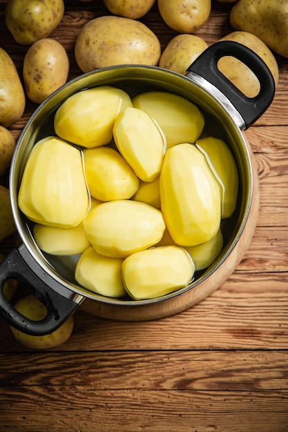 Vers geschilde aardappelen op een houten tafel.