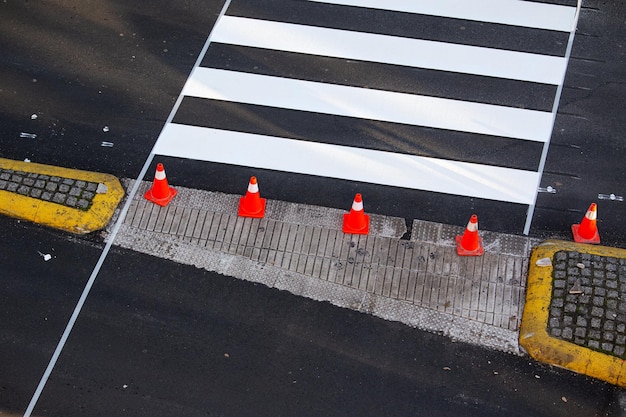 Vers geschilderd zebrapad op een stadsweg met kegels en plakband op het asfalt