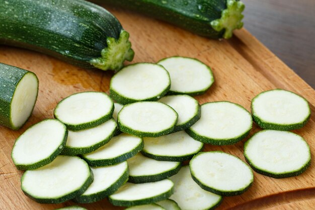 Vers gesneden courgette op snijplank op houten achtergrond