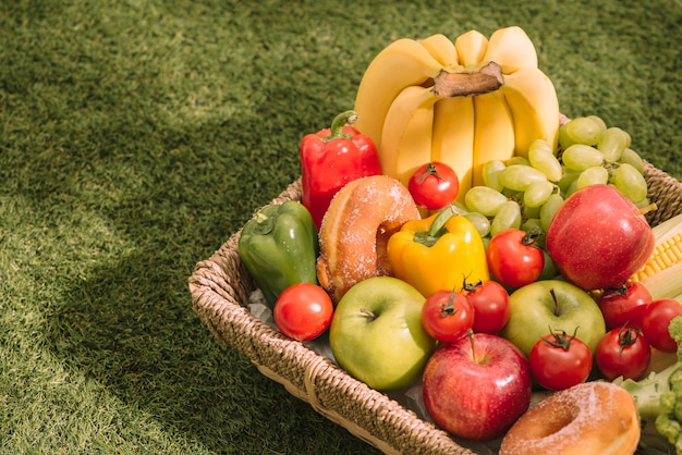 Vers gezond tropisch fruit op een picknickdeken op het gras met druiven, appel, grapefruit, sinaasappel en banaan