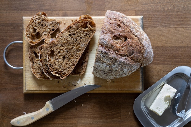 Foto vers graanbrood in plakjes gesneden op keukenbord, bovenaanzicht