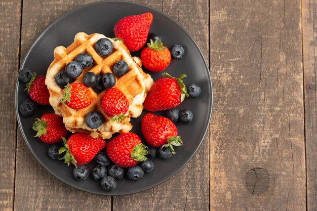 Vers huisgemaakt eten van Belgische bessenwafels met honingchocolade aardbei bosbes