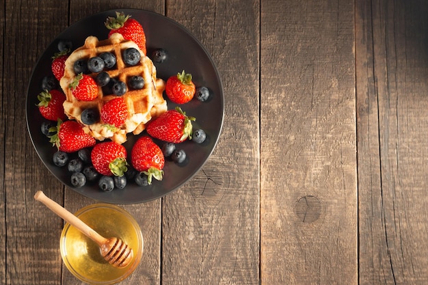 Vers huisgemaakt eten van Belgische bessenwafels met honingchocolade aardbei bosbes