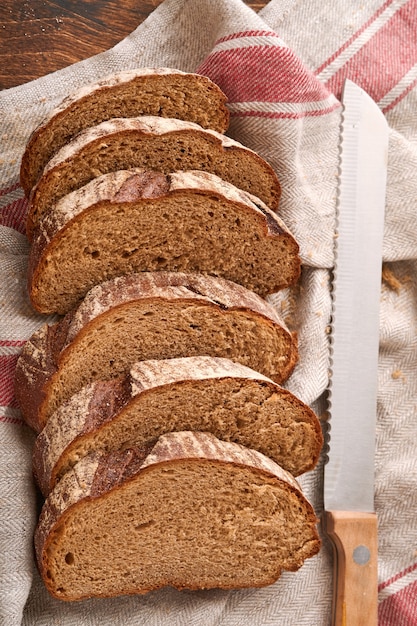 Vers huisgemaakt roggebrood. traditioneel spelt zuurdesembrood in plakjes gesneden op een rustieke houten achtergrond. concept van traditionele bakmethoden voor gezuurd brood. selectieve aandacht.