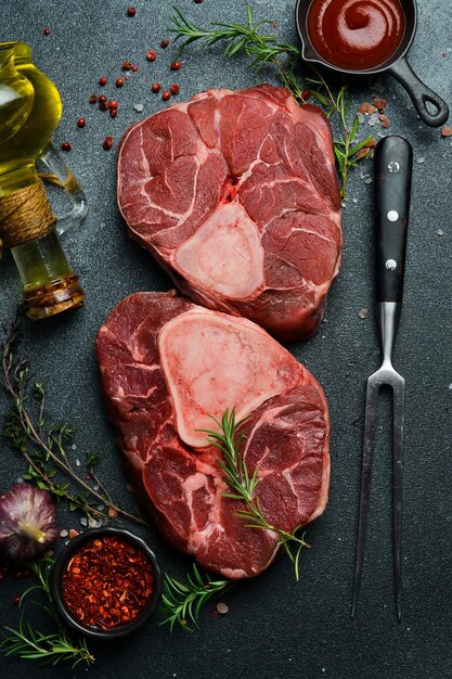 Foto vers kalfsvlees osso buco shank steak italiaanse ossobuco zwarte achtergrond bovenbeeld kopieerruimte