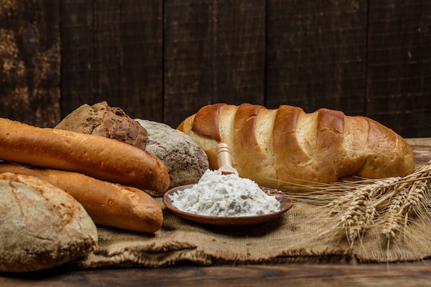 Vers knapperig brood met bloem op een houten tafel