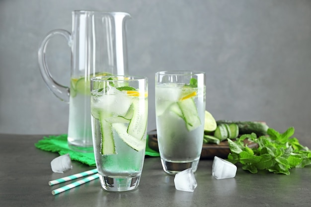 Vers komkommerwater met citroen en munt in glaswerk op lijst