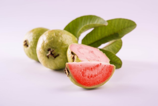 Vers rood guavefruit, ook bekend als Amrood in het Hindi en Peru in Marathi, geserveerd in een mand als geheel of plakjes op een kleurrijke achtergrond. Selectieve focus