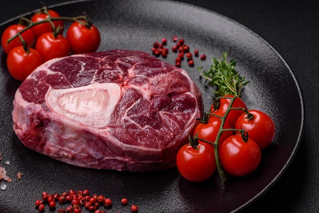 Vers rundvlees ossobuco steak met zoute specerijen en kruiden op gestructureerde betonnen achtergrond