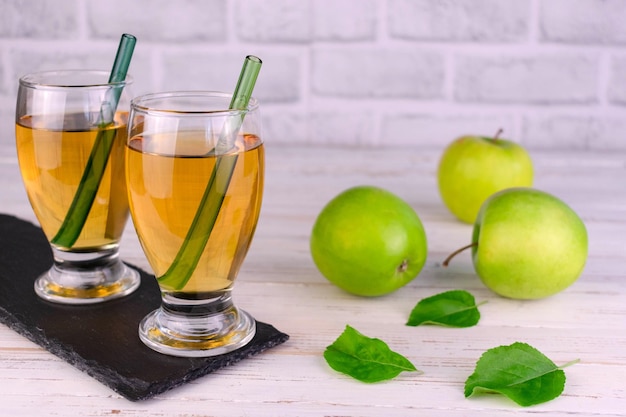 Vers sap van biologische appels in glazen op een witte houten tafel.